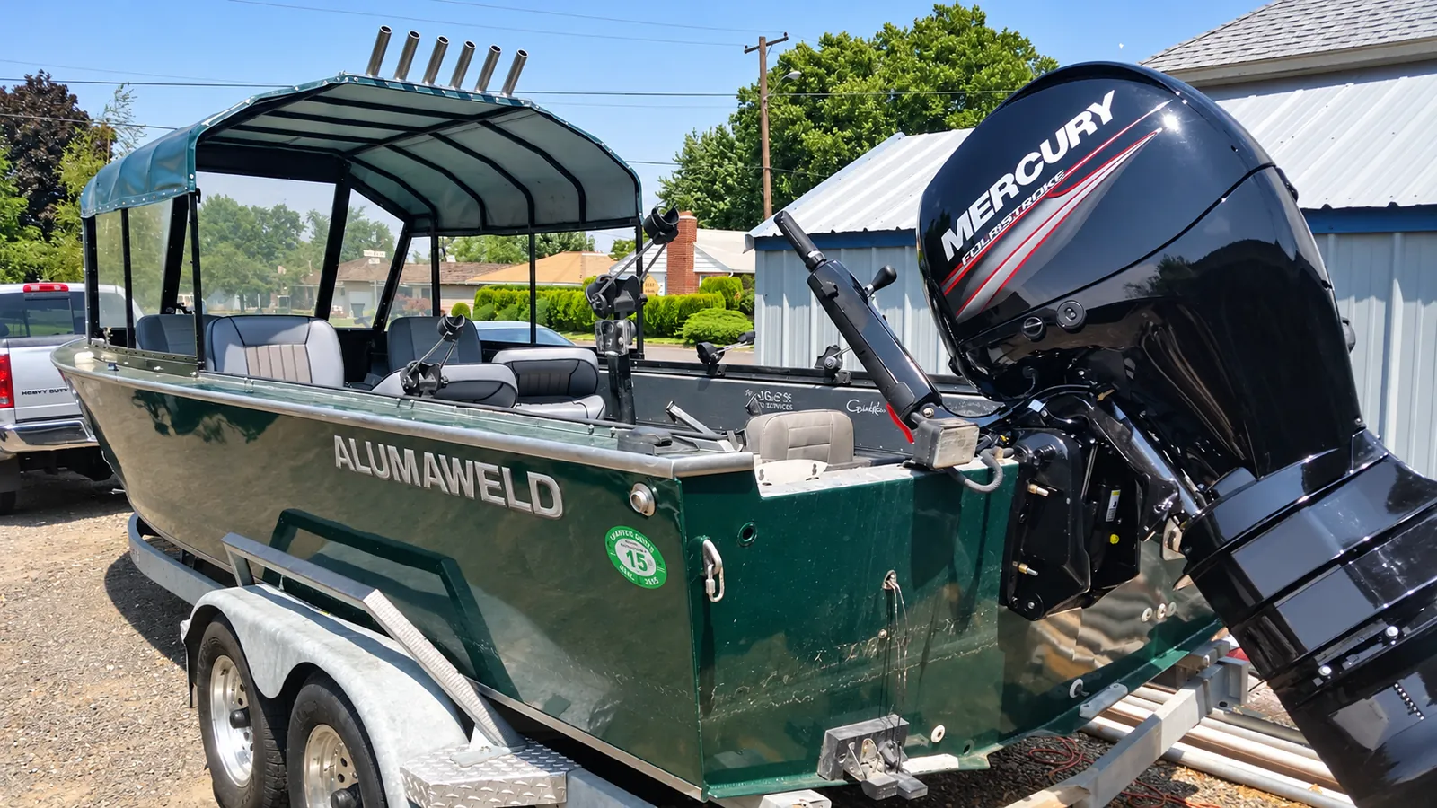Dark green Alumaweld guide boat with a covered canopy, six rod holders and a Mercury outboard, on its trailer
