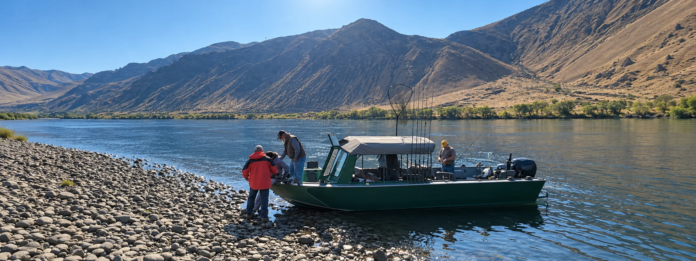 Guide boat with a canopy at a gravel shore below sunlit hills, guests stepping aboard