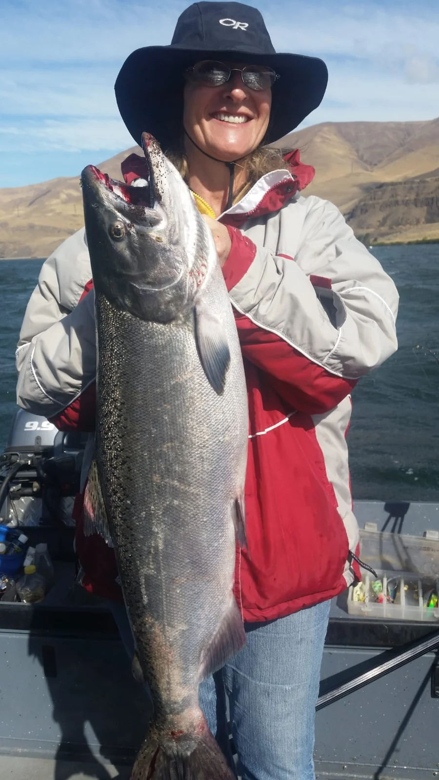 Smiling woman in a wide-brim hat holding a silver Chinook