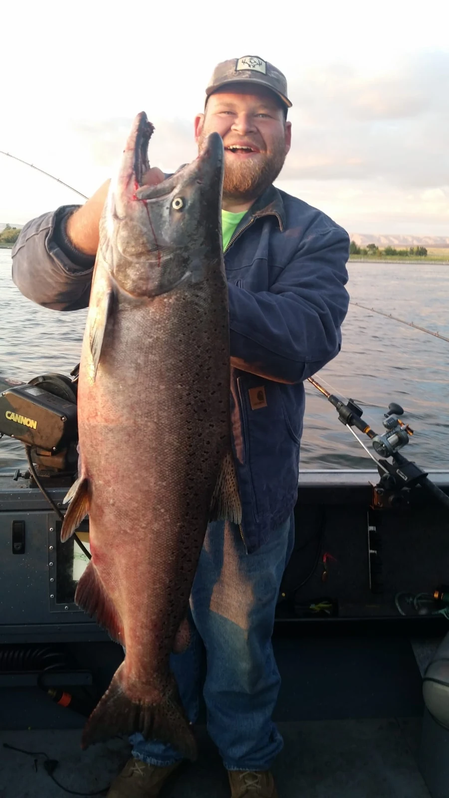 Bearded man in a blue jacket holding a dark fall Chinook