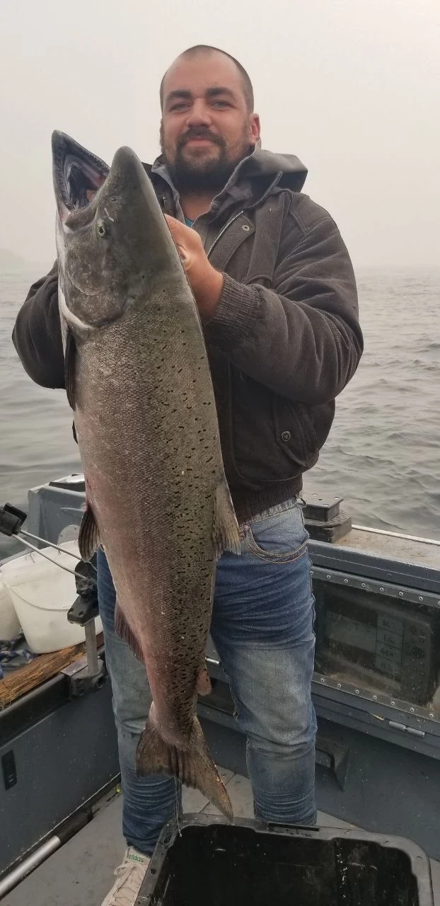 Angler holding a fall Chinook salmon on the boat