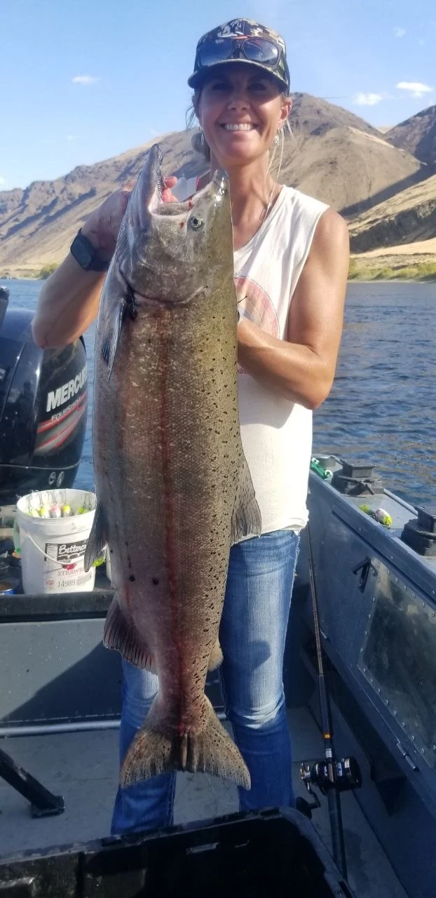 Smiling angler holding a large fall Chinook salmon