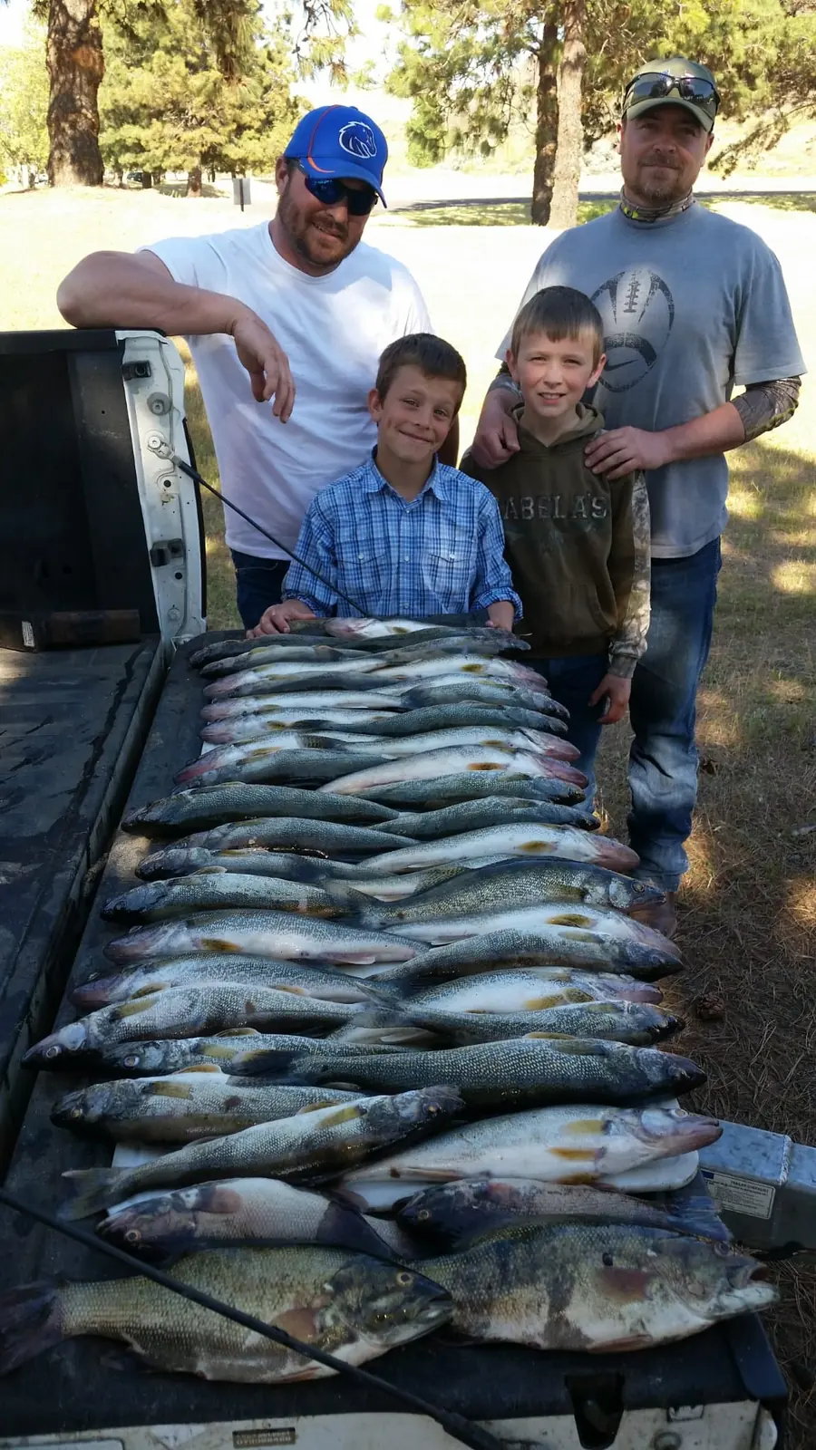 Family behind a pickup bed filled with a day’s walleye