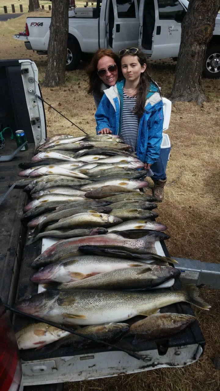 Mother and daughter behind a table of walleye
