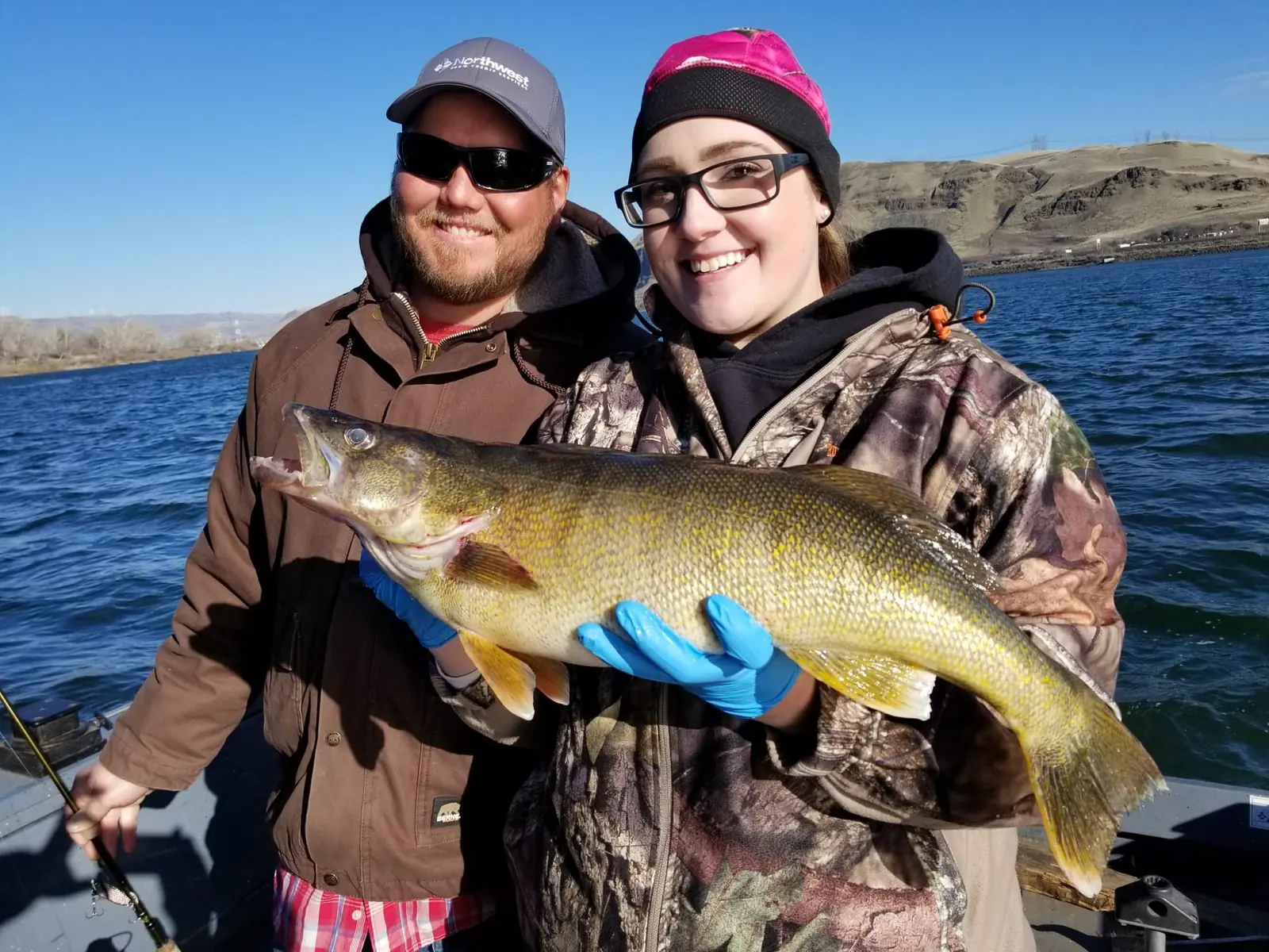 Couple on the water holding one big walleye between them